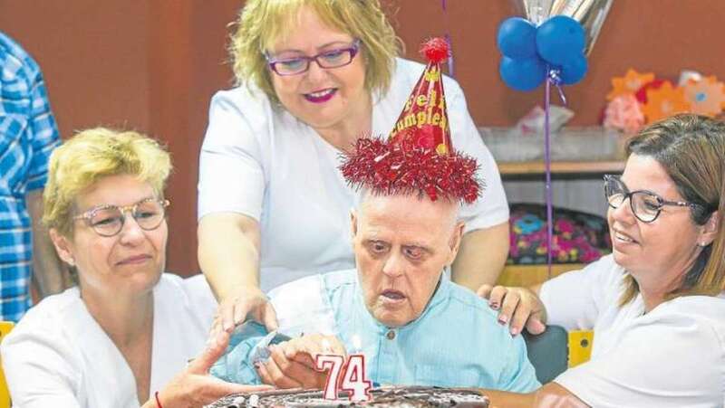 Gerardo, con gorro y todo, dispuesto a soplar las velas de una inmensa tarta. Detrás de él está Nieves, a la que él tiene como su madre (Foto Borja Suárez/C7)